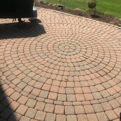 The natural color of the brick in this paver patio is revealed after professional cleaning services are rendered.